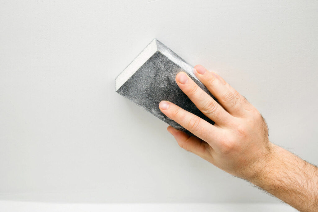 Sanding drywall with a sanding sponge.