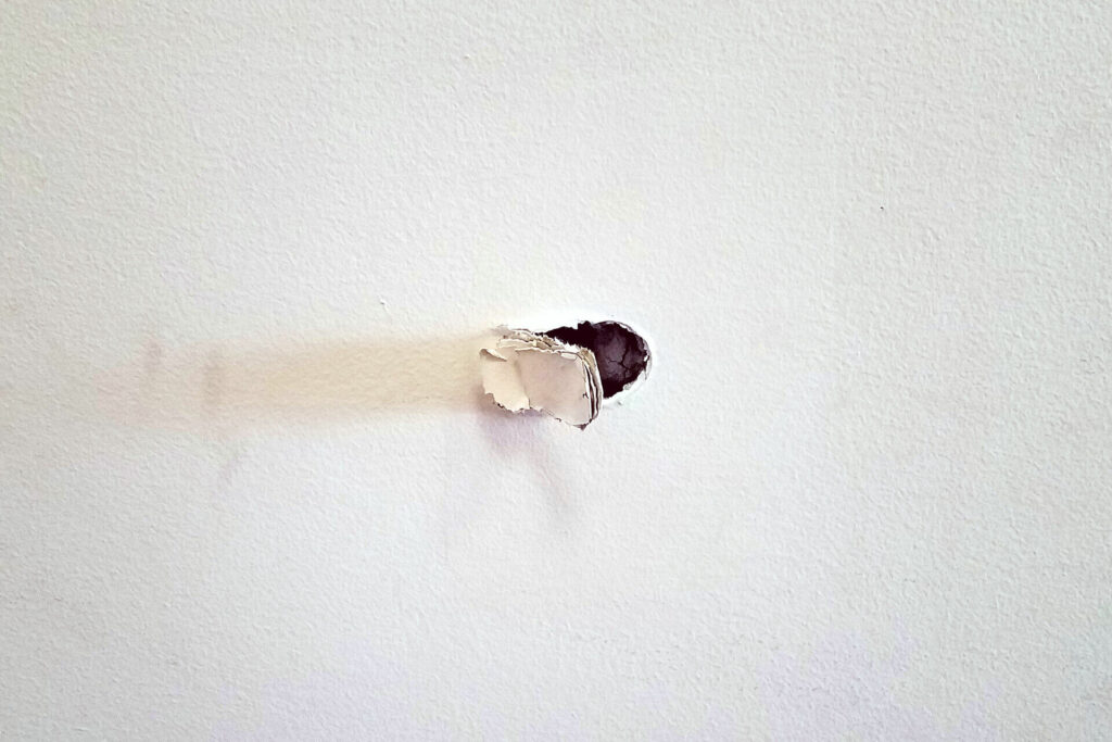A small hole in drywall.